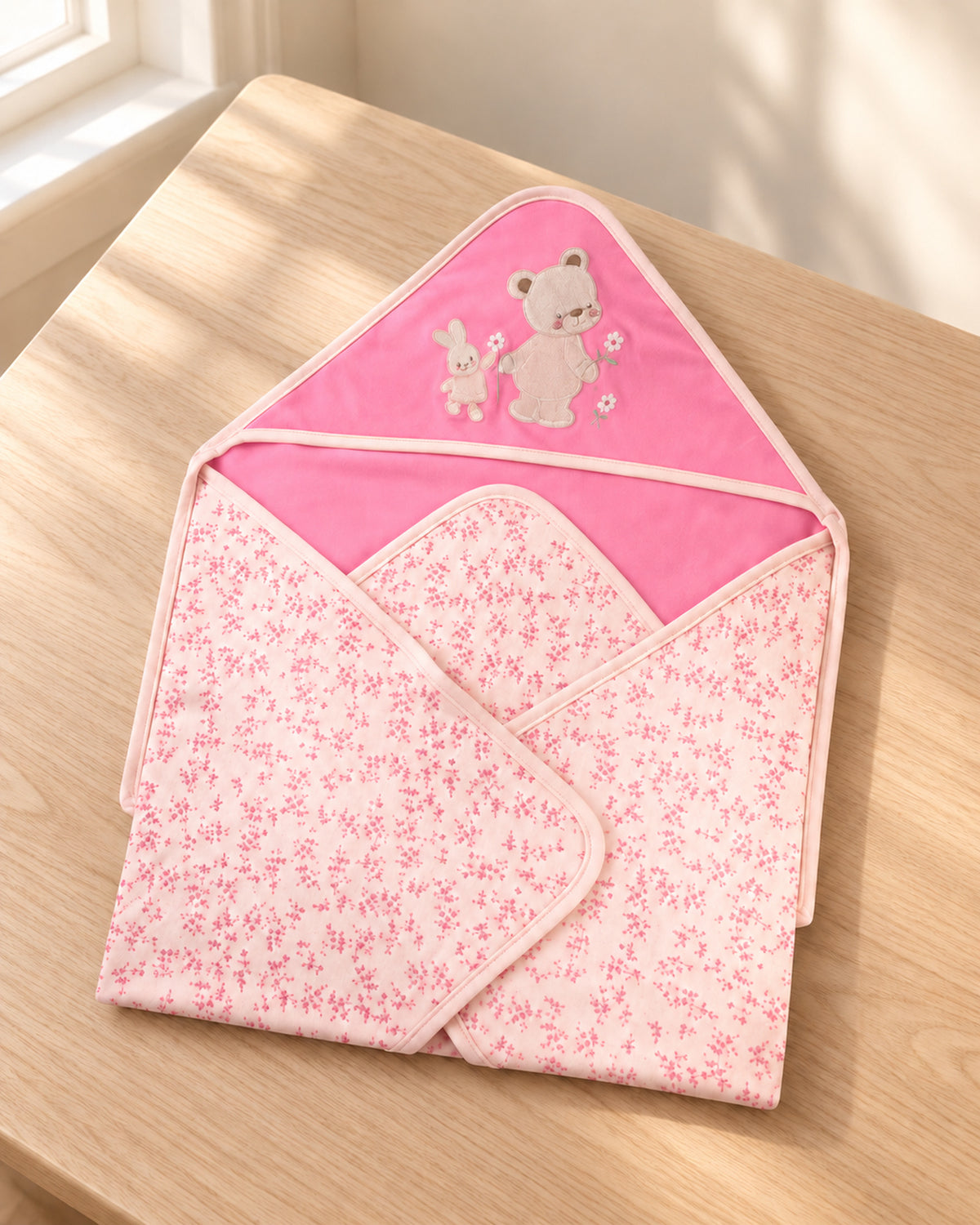 Funny Bunny pink hooded baby wrap, three-quarter tabletop