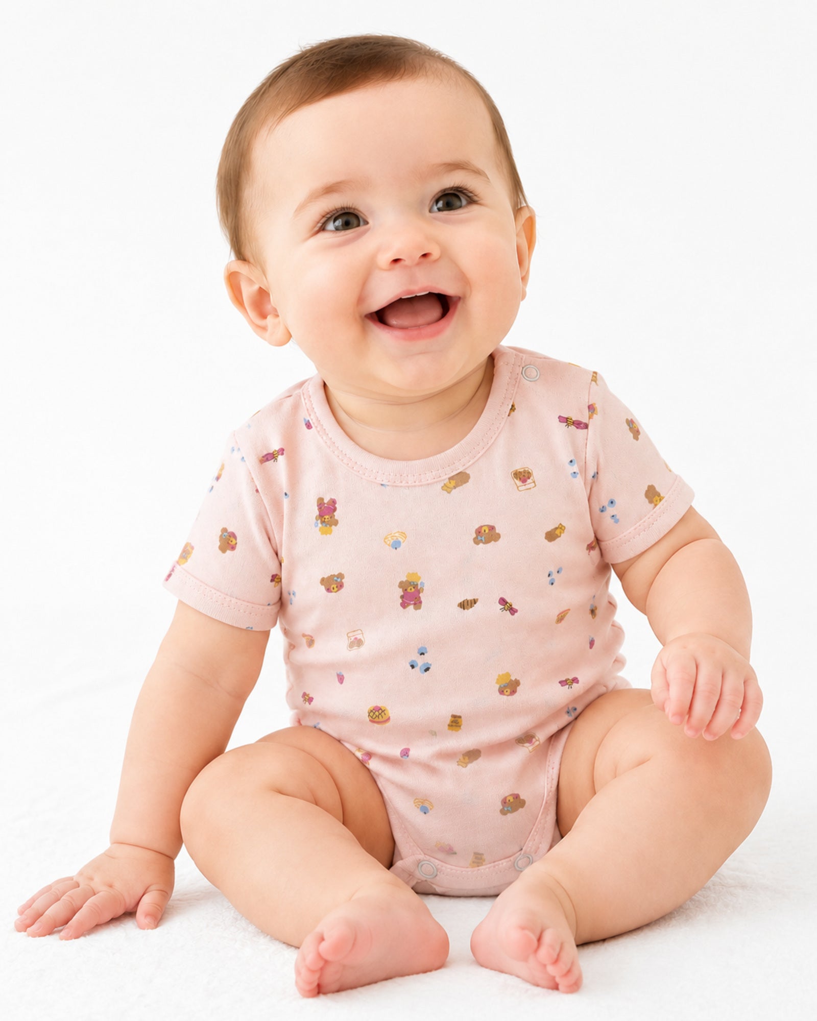 Baby wearing pale pink short-sleeve bodysuit with teddy bear treats print