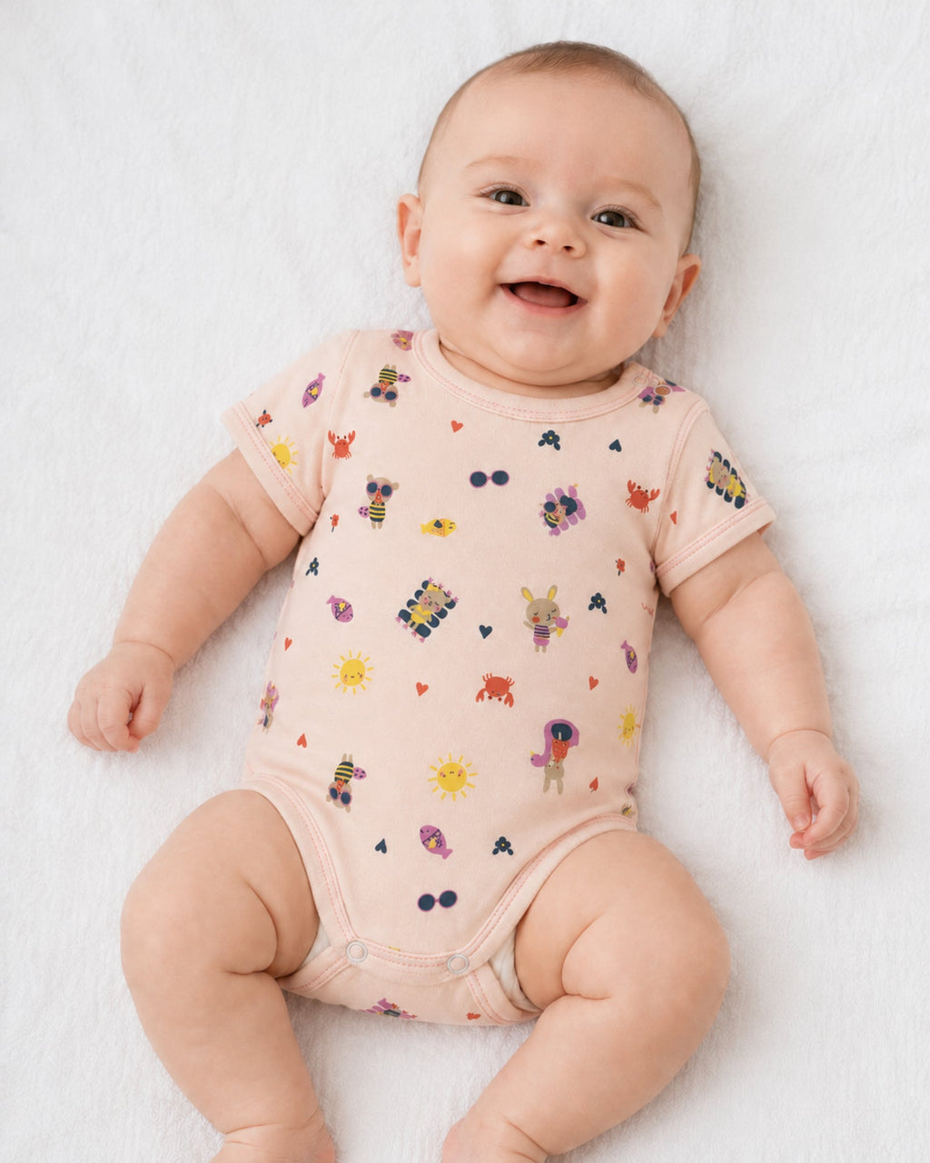Baby wearing pale peach short-sleeve illustrated bodysuit on white
