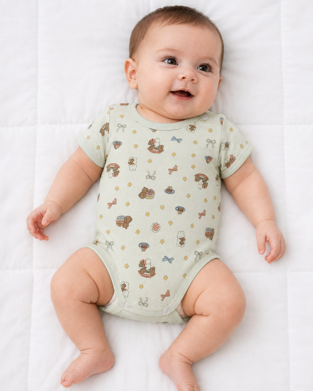 Baby wearing pale mint short-sleeve rocking horse and teddy print bodysuit on white