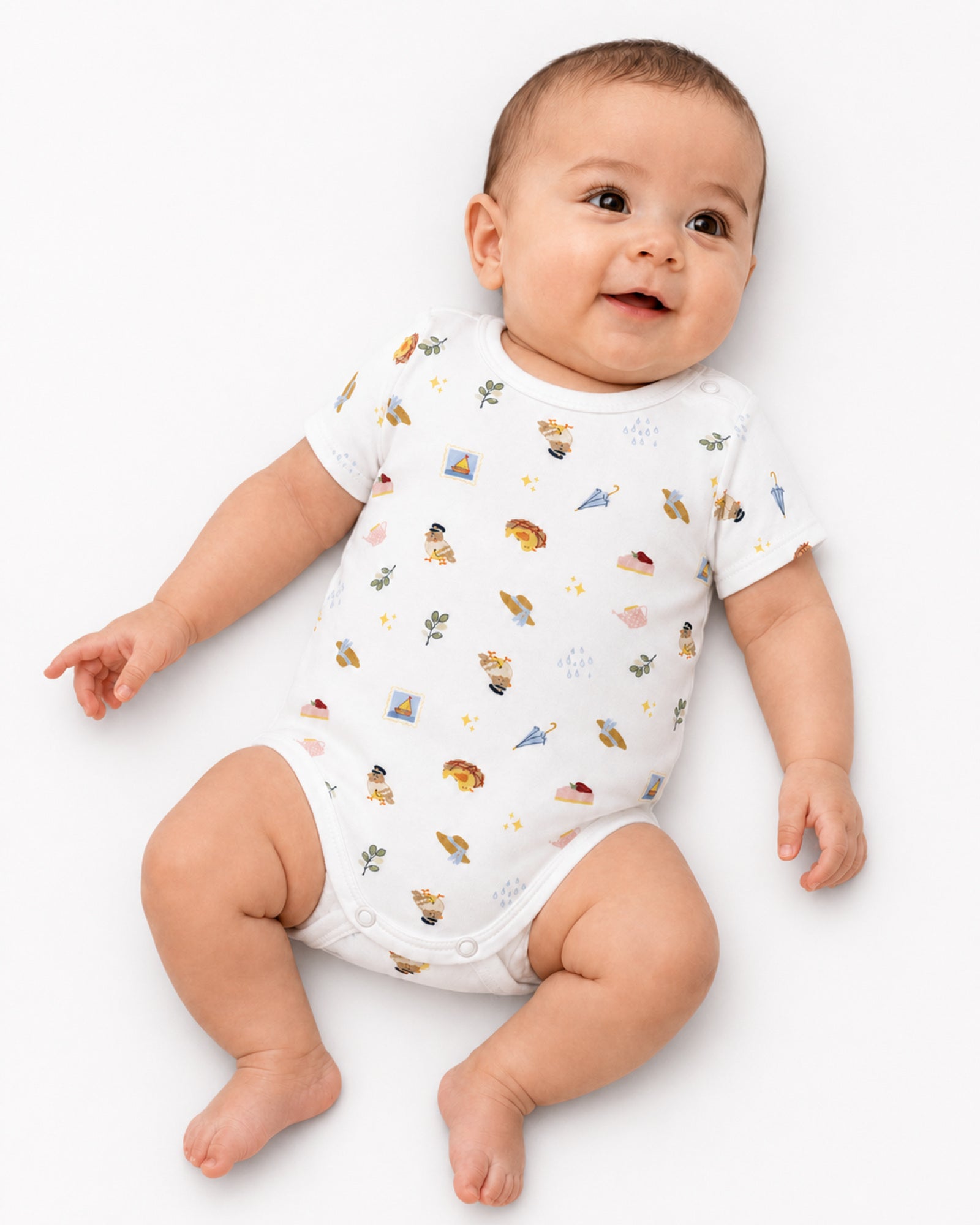 Smiling baby wearing white short-sleeve picnic and travel print bodysuit on white