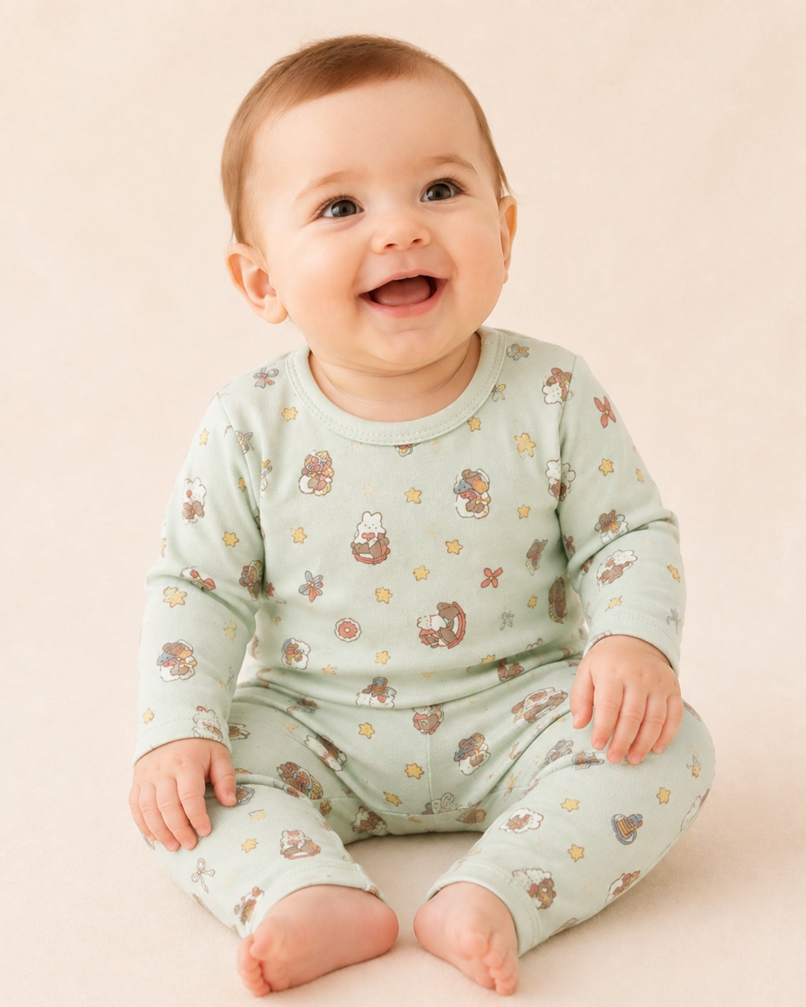 Baby wearing pale mint long-sleeve two-piece set with teddy bear and rocking horse print