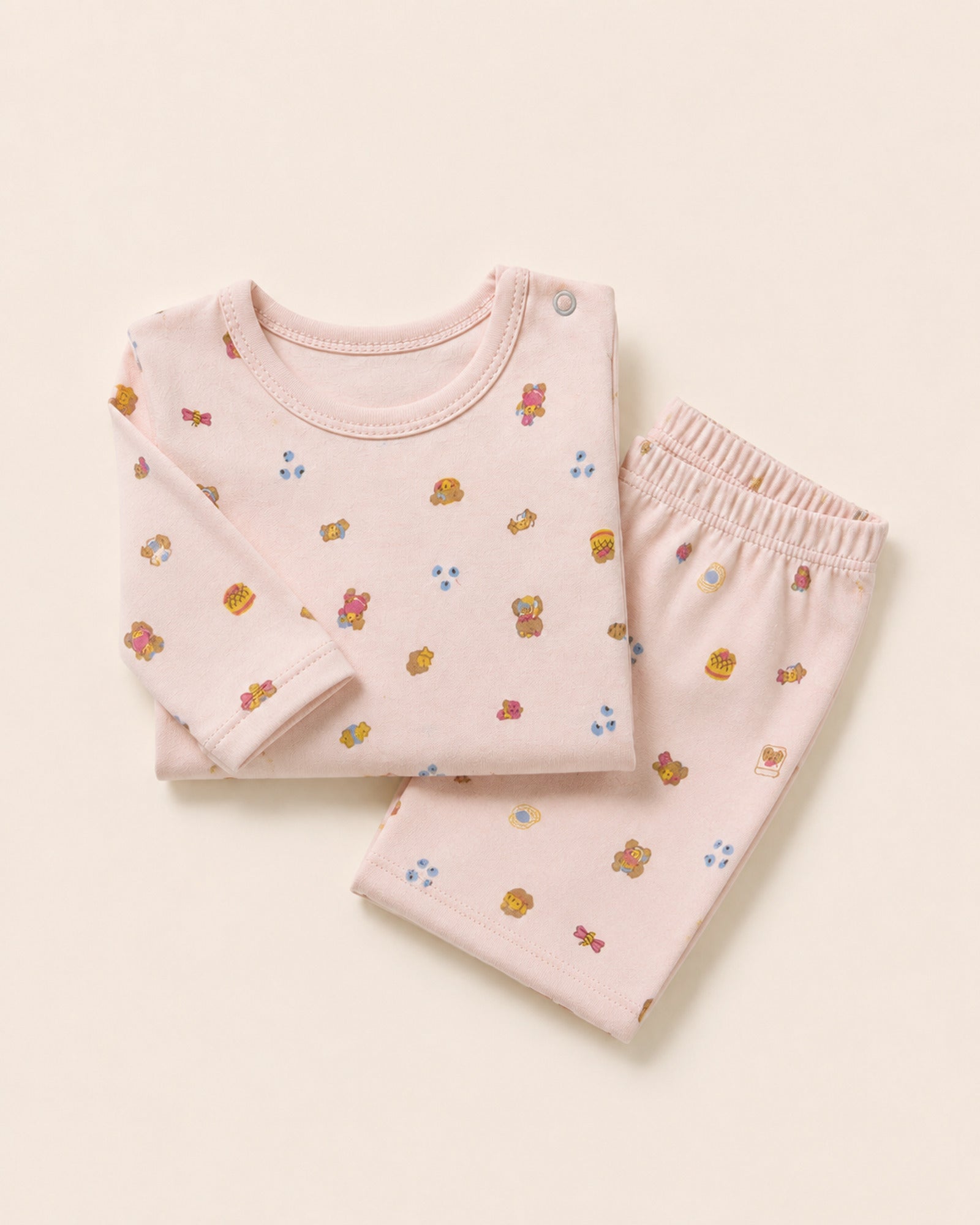 Pale pink long-sleeve baby top and matching trousers, folded composition