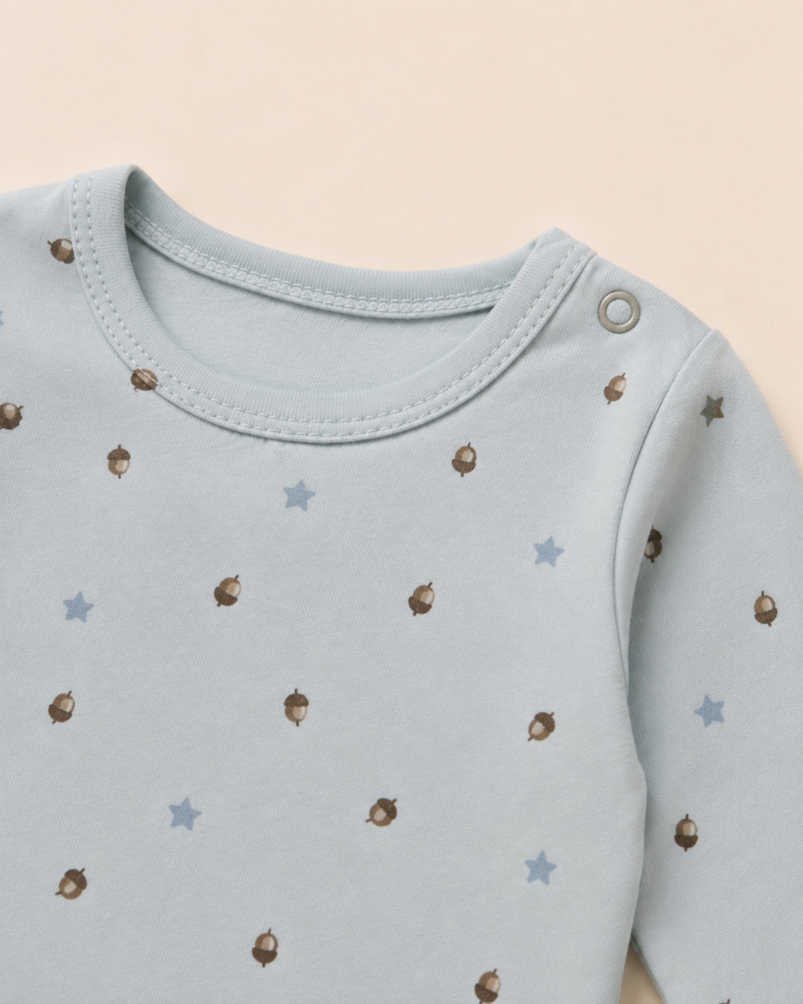 Pale powder-blue baby set neckline, shoulder snap, stitching and acorn stars print detail