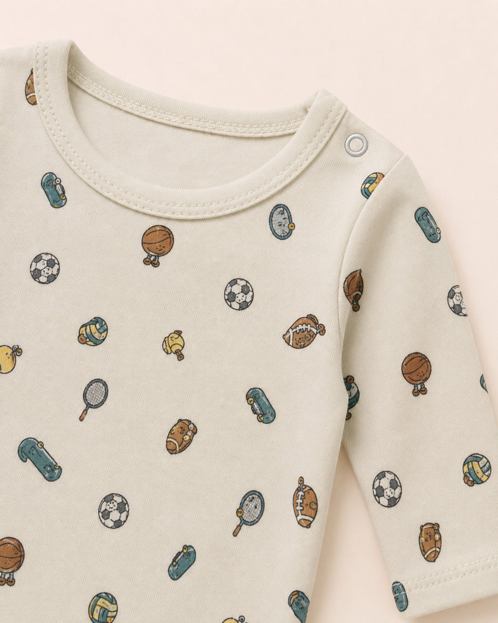 Pale cream baby set neckline, shoulder snap, stitching and sports print detail