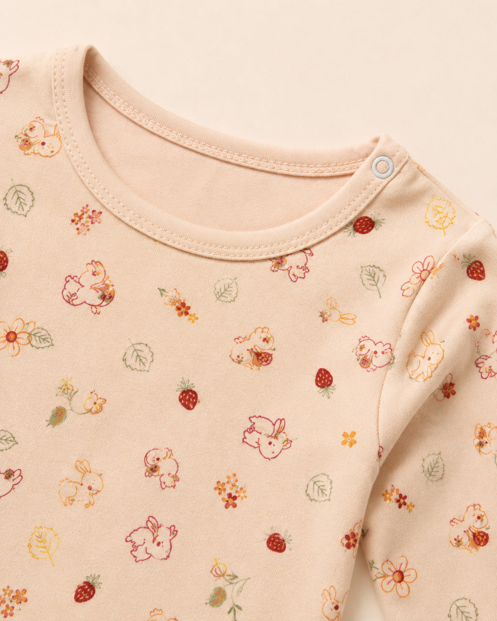 Pale peach-pink baby two-piece set – neckline, shoulder snap and print detail