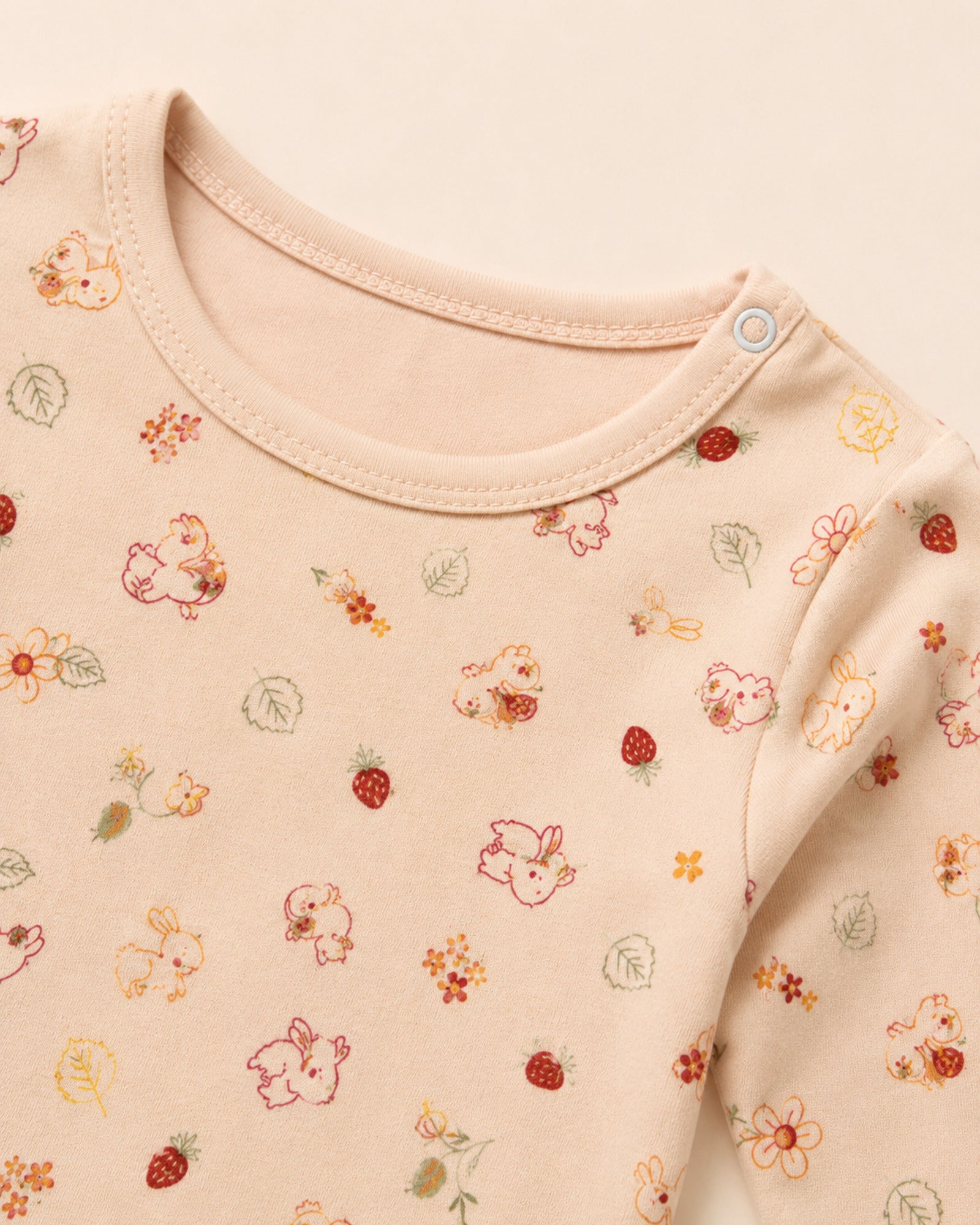 Pale peach-pink baby two-piece set – neckline, shoulder snap and print detail