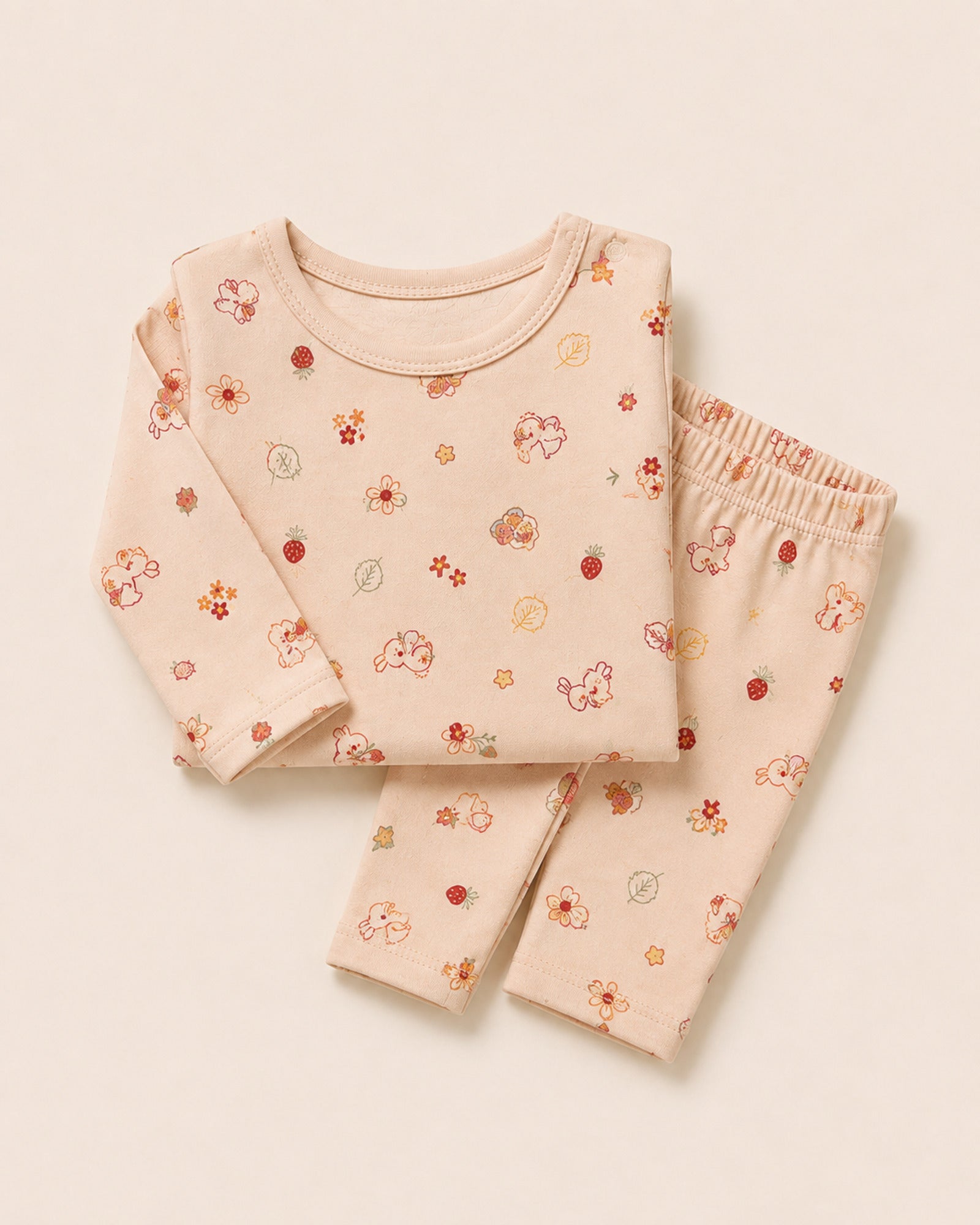 Pale peach-pink baby two-piece set with bunny, flower and strawberry print – folded composition