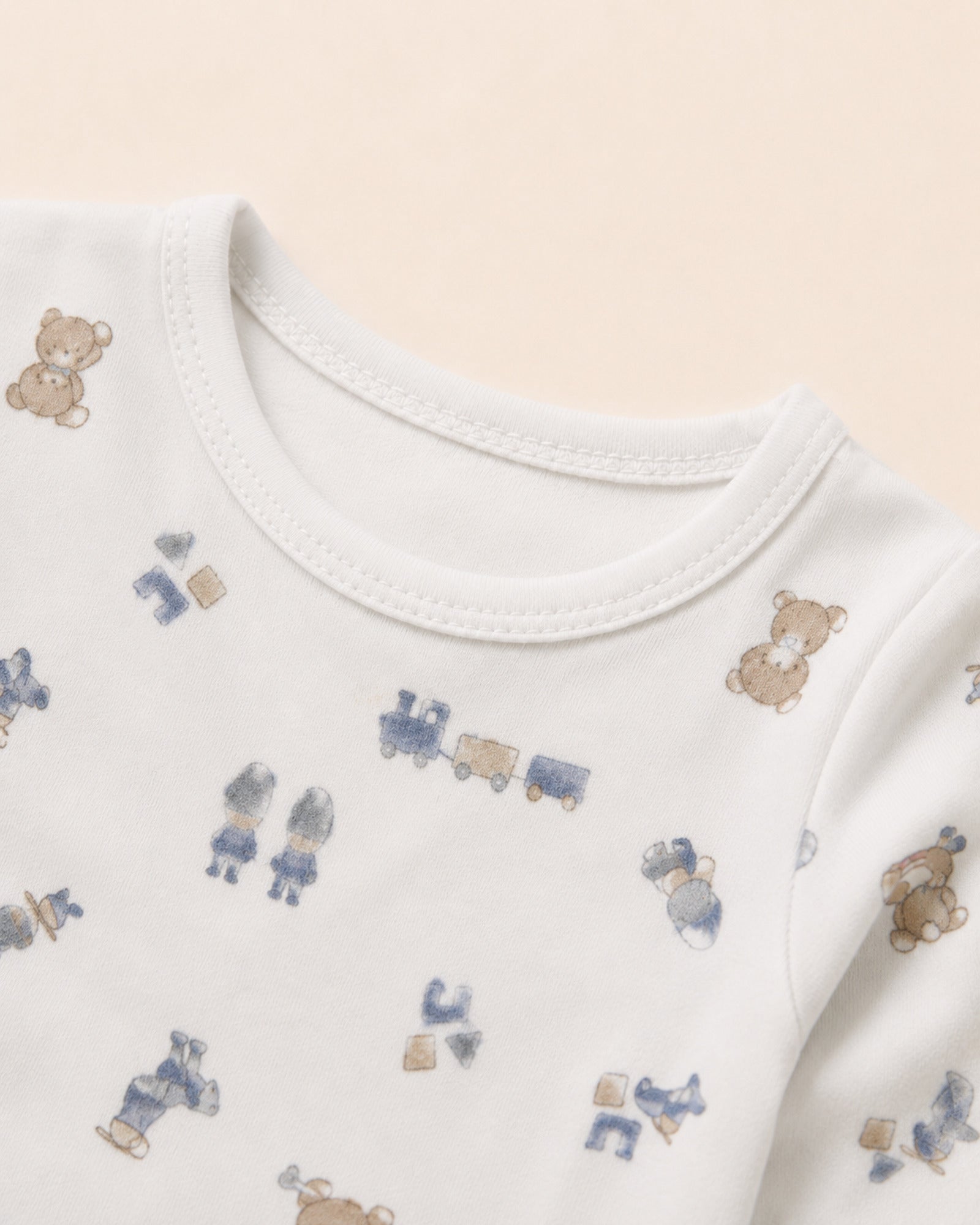 White baby two-piece set with teddy bear, train and toys print – neckline and toy-print detail