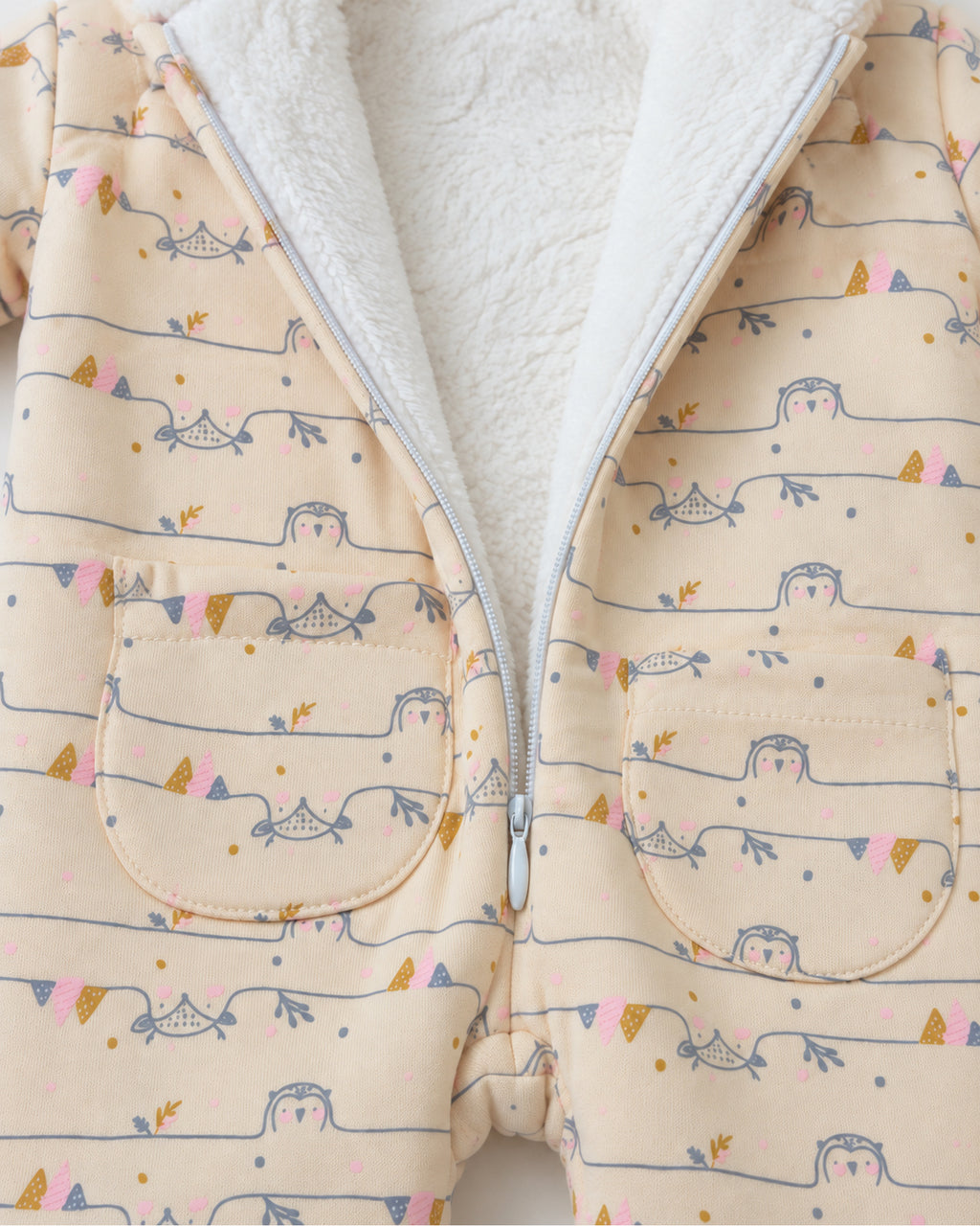 Cream owl print jumpsuit open zip white fleece lining and curved patch pockets detail