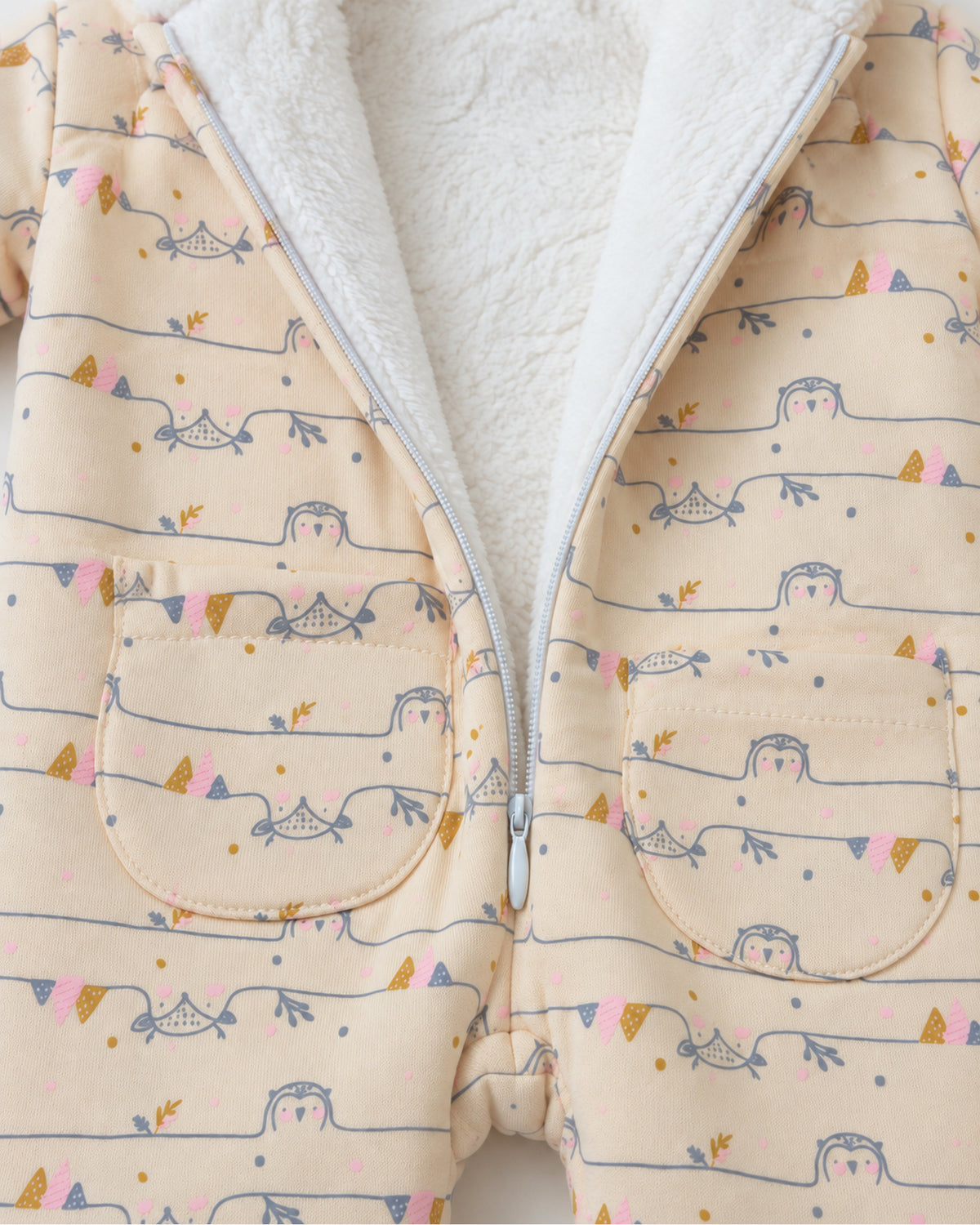 Cream owl print jumpsuit open zip white fleece lining and curved patch pockets detail