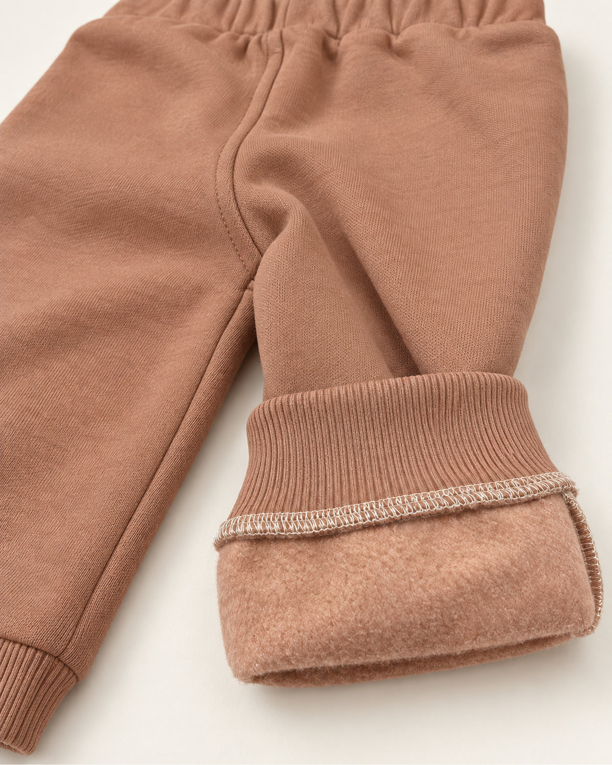 Dark dusty rose baby girl embroidered jacket, XOXO top and joggers set, turned trouser cuff showing the brushed inner surface