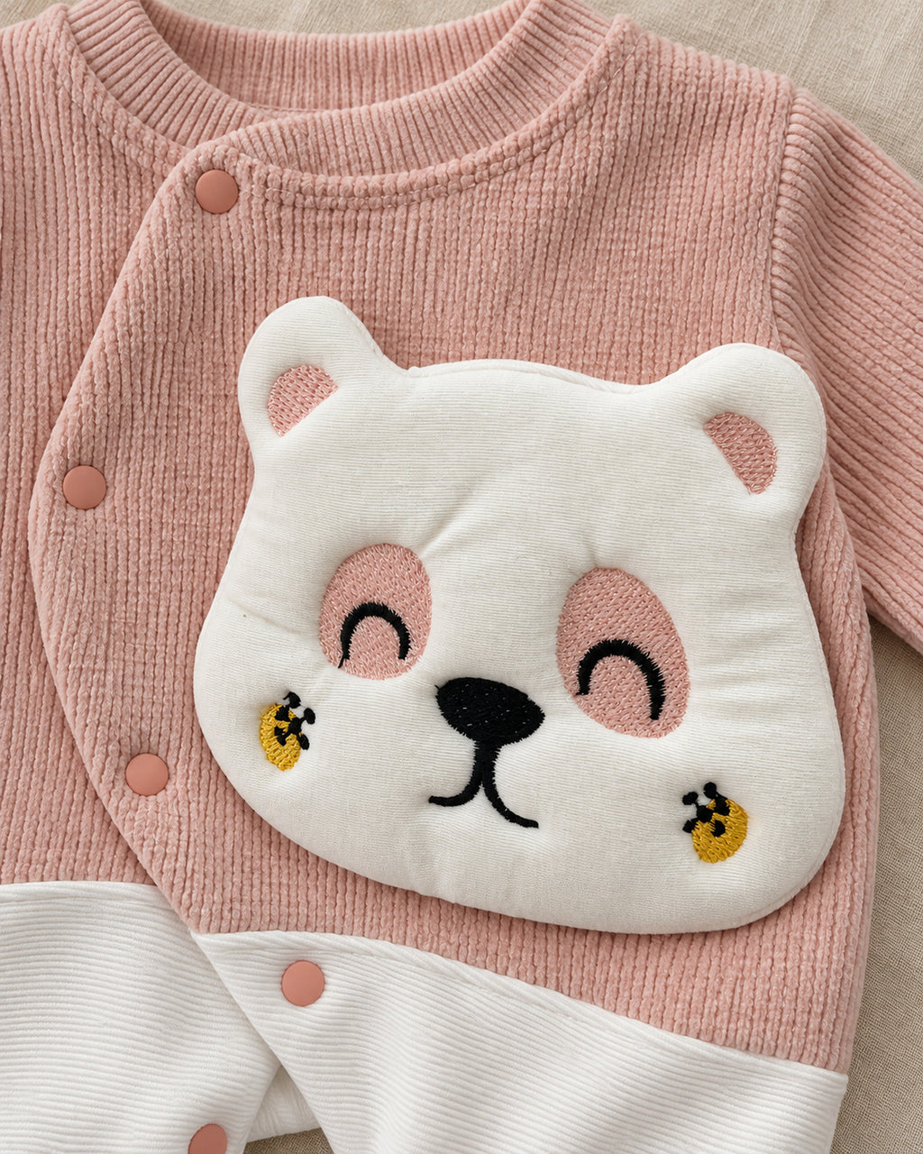 Dusty rose baby bear sleepsuit, applique and snap detail